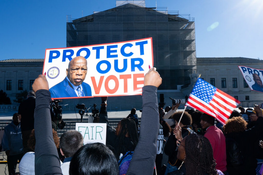 Protestor holds sign stating, "Protect our vote"