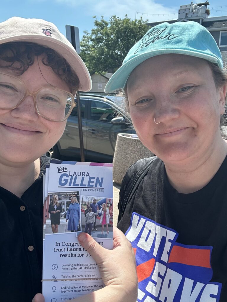VSA volunteers smiling for a photo and holding up canvassing materials